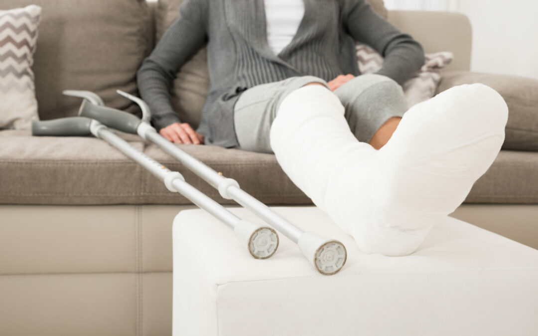 Woman With Plastered Leg Sitting On Couch